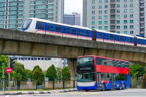 Photography A futuristic monorail glides above a red and blue double-decker bus stopped at a
