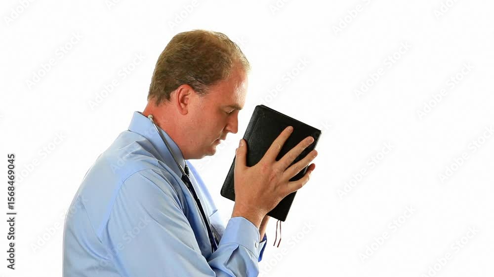 Doctor holding Bible and praying white background Doctor holding Bible and praying white background