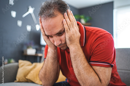 Man sitting alone at home looking sad and distraught
