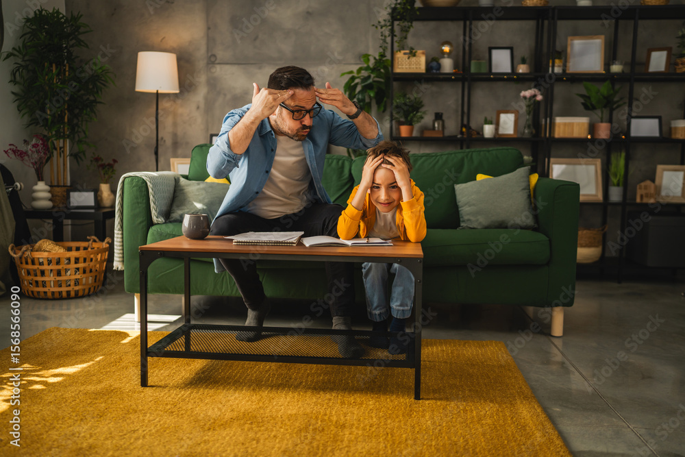Obraz premium exhausted father help son to finish his homework