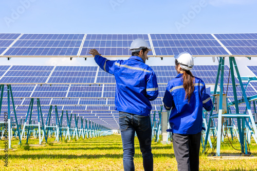 Architects and engineer team woman and man working on solar panel and blueprints with Solar photovoltaic equipment on factory construction site. meeting, planing, brainstorming. Factory worker. 