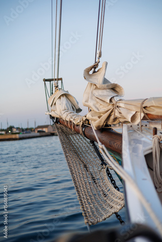 Bow of Sailboat with Furled Sail and Rigging at Sunset