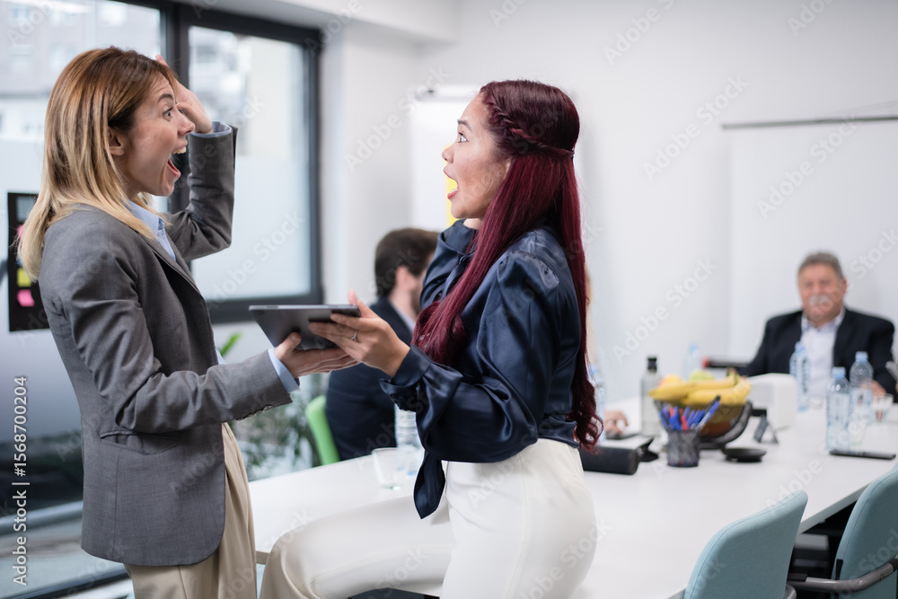 Fototapeta premium Two Colleagues Expressing Surprise and Excitement During a Meeting in a Modern Office Setting