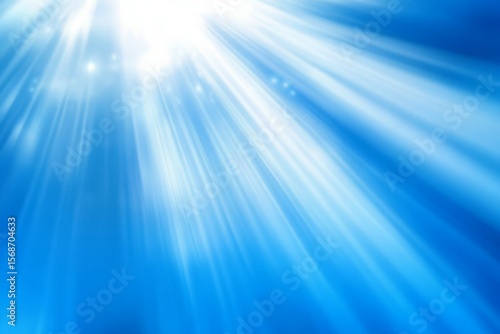 Bright light rays emanating from a central point, shining through a clear blue sky with bokeh effect.