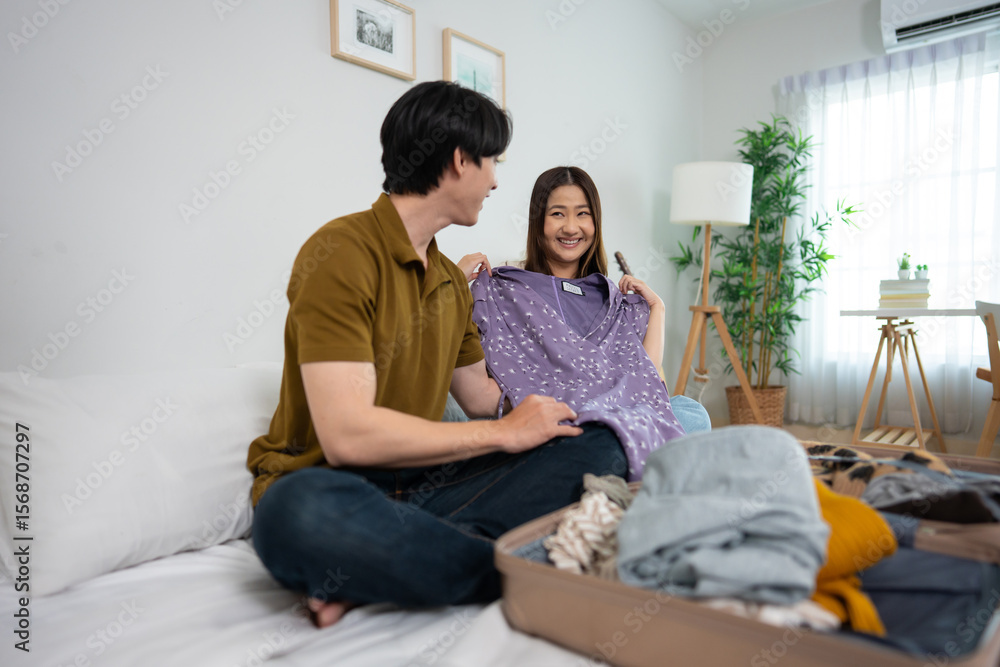 Obraz premium Asian young beautiful couple preparing clothes and packing suitcase.