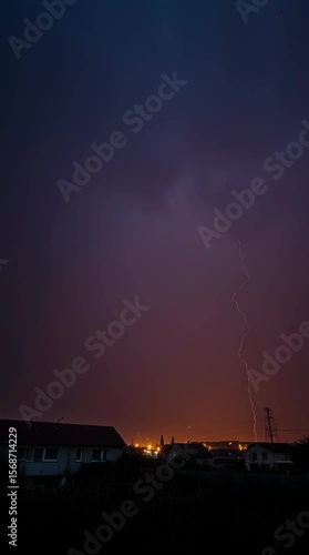 Dramatic lightning strike over a small town during a powerful nighttime thunderstorm