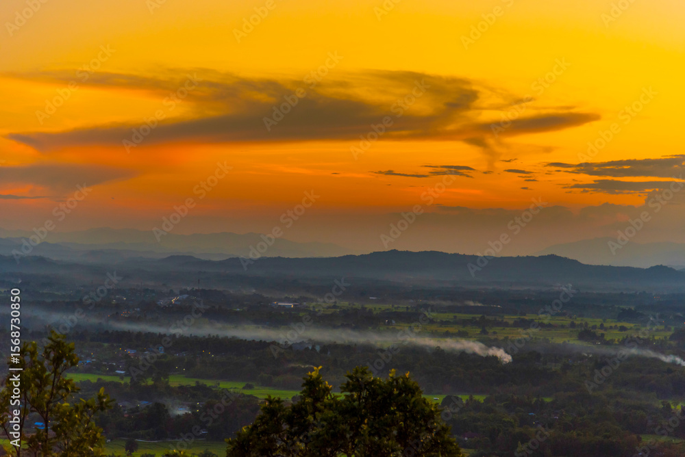 Fototapeta premium Sunset mountain range beautiful landscape mist foggy sunrise beam. Golden sky Mountain landscape foggy windy mountain. Amazing Landscape cloud sky on sunrise. Countryside gold sunlight heaven scene