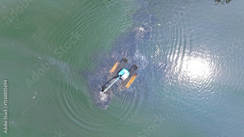 Slika na platnu View from above of an excavator dredging a lake on the riverbank in North Jakart