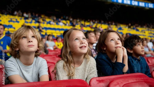 Children watching a live soccer match from the front row, eyes wide with excitement, colorful seats behind them