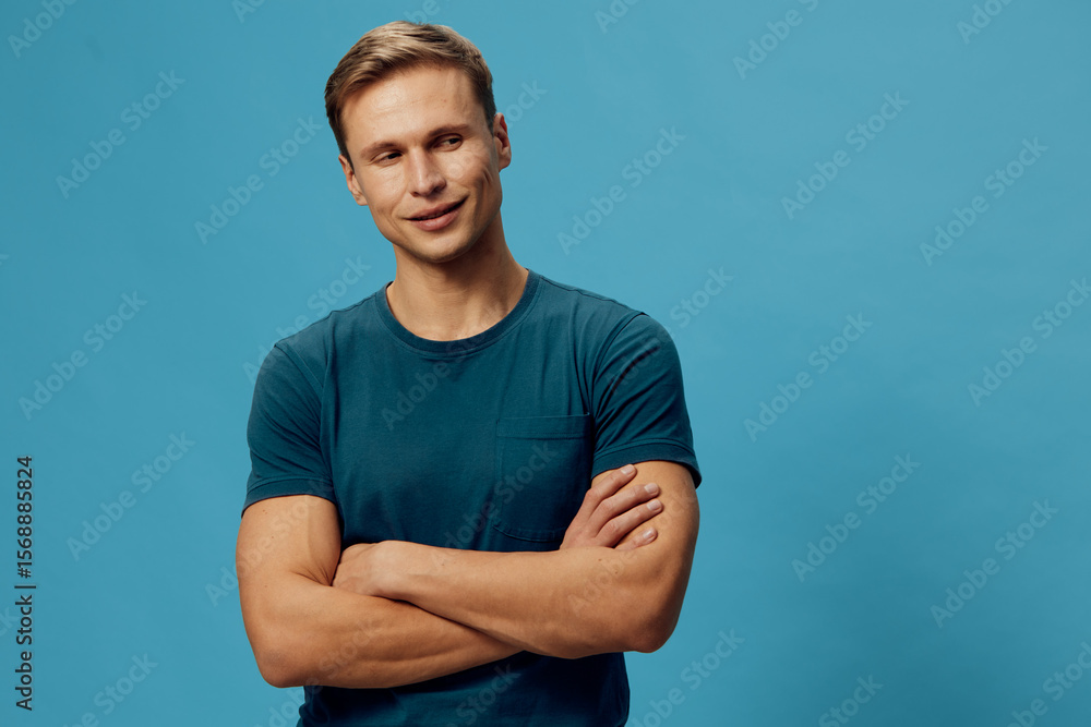 Handsome young man with short brown hair wearing casual blue t-shirt looking confidently at camera isolated on plain vibrant blue background studio portrait. People lifestyle concept Handsome young man with short brown hair wearing casual blue t-shirt looking confidently at camera isolated on plain vibrant blue background studio portrait. People lifestyle concept