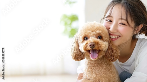 Smiling woman hugging toy poodle at home
