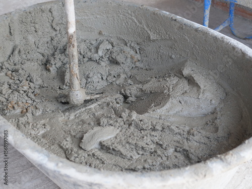 Mortar cement with hoe in tray as grey texture background for industry construction concept.