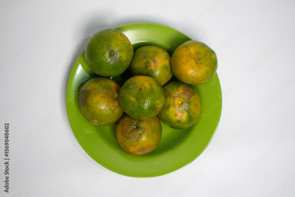 Oranges arranged in a circle on a bright green plate. Oranges arranged in a circle on a bright green plate.