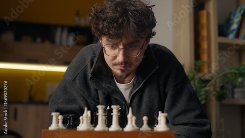Photography Focused Hispanic guy player playing chess mind game at home hipster look chessbo