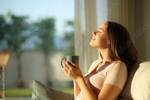 Canvastavla Happy woman holding coffee cup breathing and enjoying aroma