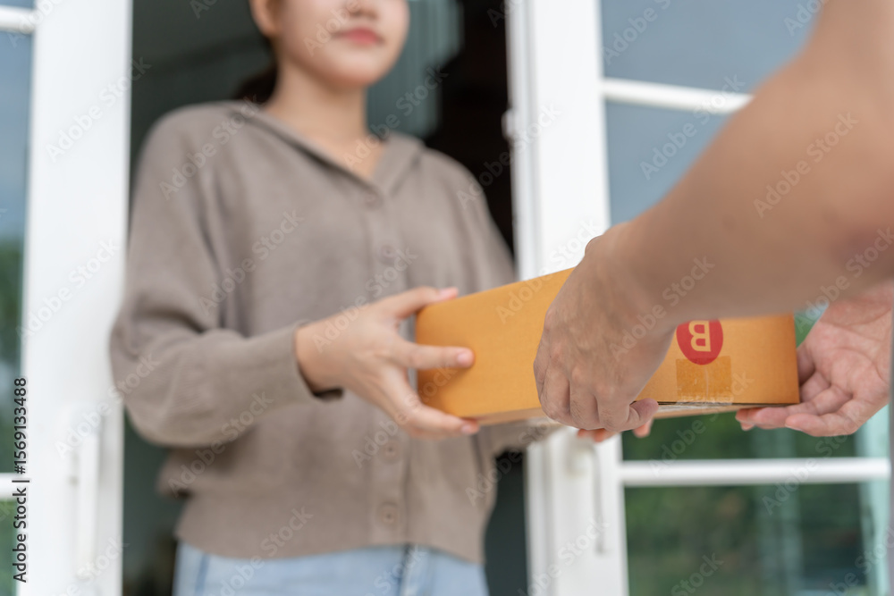 Obraz premium Happy smiling woman receives boxes parcel from courier in front house. Delivery man send deliver express. online shopping, paper containers, takeaway, postman, delivery service, packages