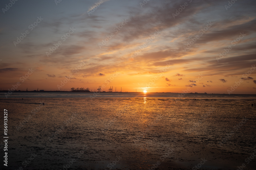 Obraz premium Dramatischer Sonnenuntergang über dem Tossensergroden, Nordsee