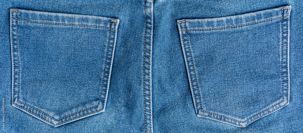 Fototapeta premium Close-up of rear view of two pockets decorated with stitches of casual comfortable blue jeans made from cozy denim fabric material used as warm everyday clothing for cold season of autumn or winter