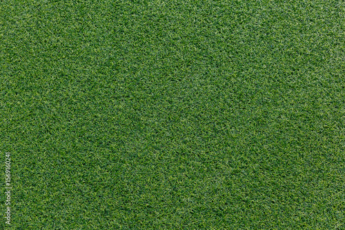 Close-up of artificial turf texture. Vivid green synthetic grass with visible fibers. Sports field or decorative surface background