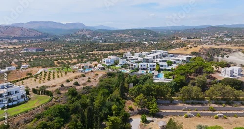 Wallpaper Mural Panoramic drone shot circling a hill with luxury vacation villas, in sunny Greece Torontodigital.ca