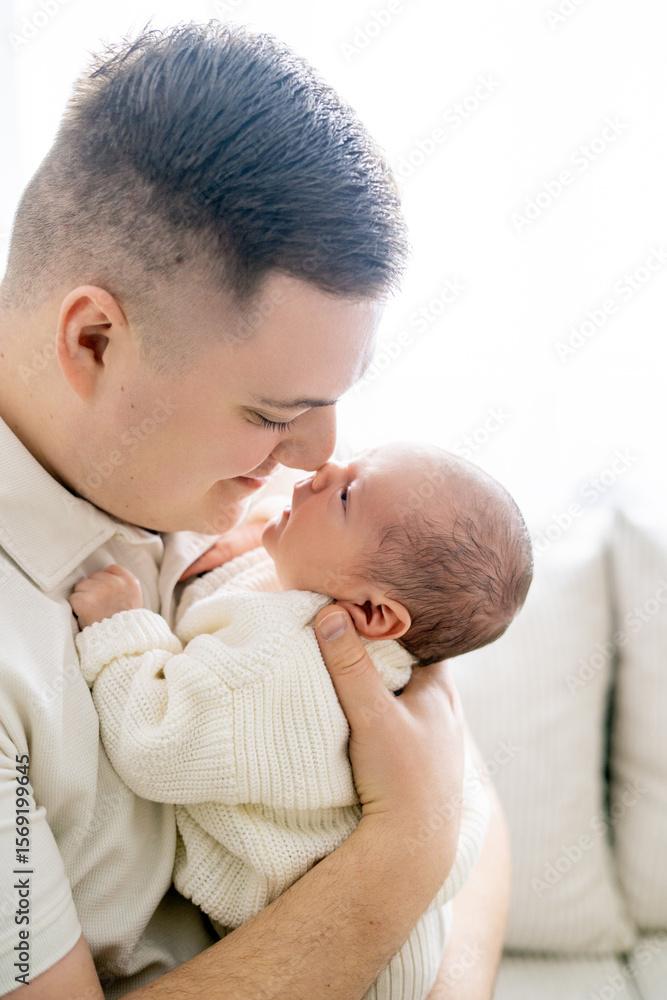 Closeup of a small newborn baby in the arms of his father. Dad hugs his little son. Closeup of a small newborn baby in the arms of his father. Dad hugs his little son.
