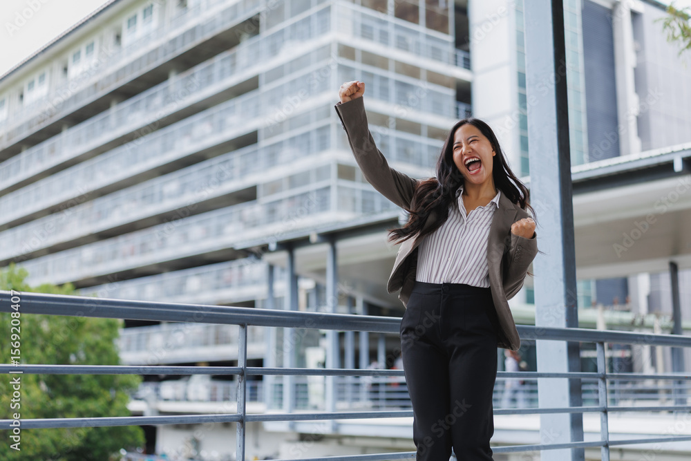 Fototapeta premium Excited businesswoman celebrating success in urban setting