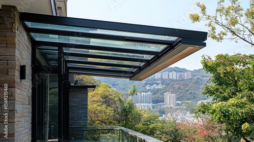 Modern glass canopy over a balcony with city and mountain views