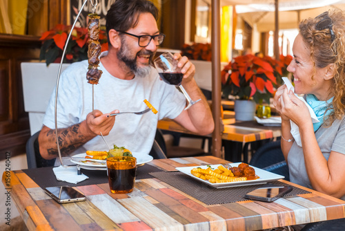 Billede på lærred Happy couple enjoying meal at restaurant – romantic date, vacation mood, weekend
