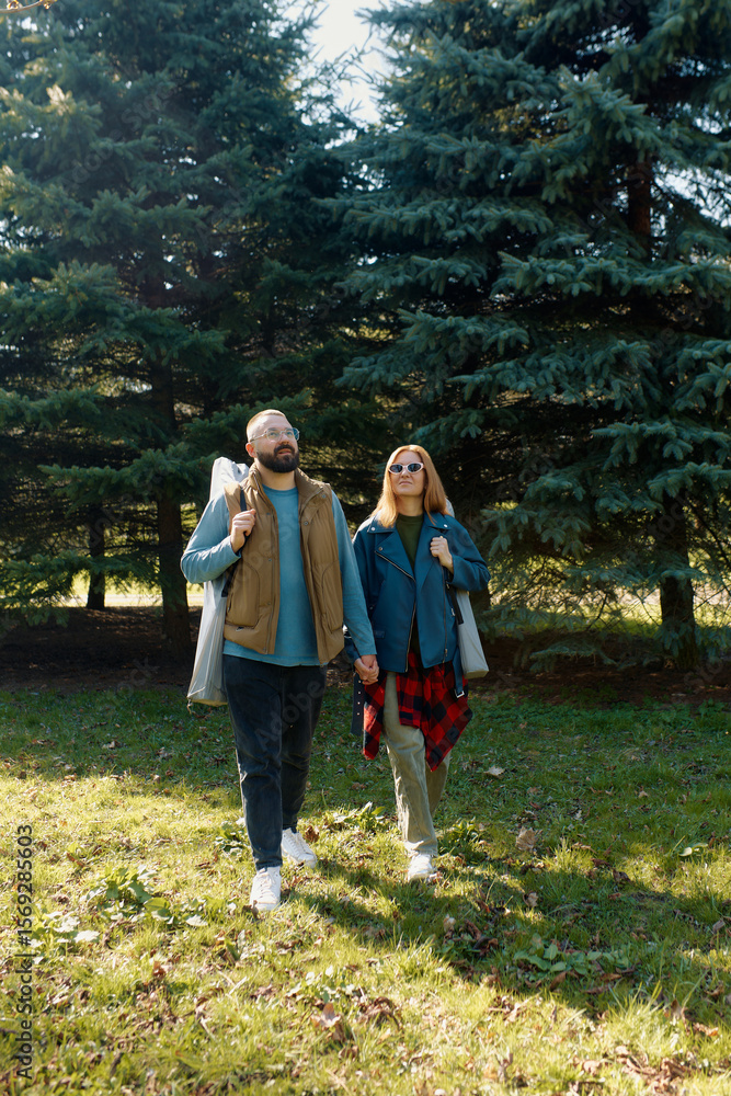 Fototapeta premium Happy couple enjoying a sunny outdoor day with folding chairs in a peaceful green area