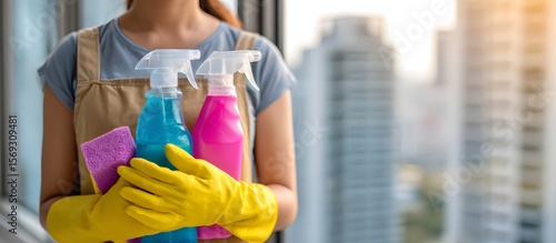 Woman holding a cleaning bucket with colorful supplies in a modern gym setting