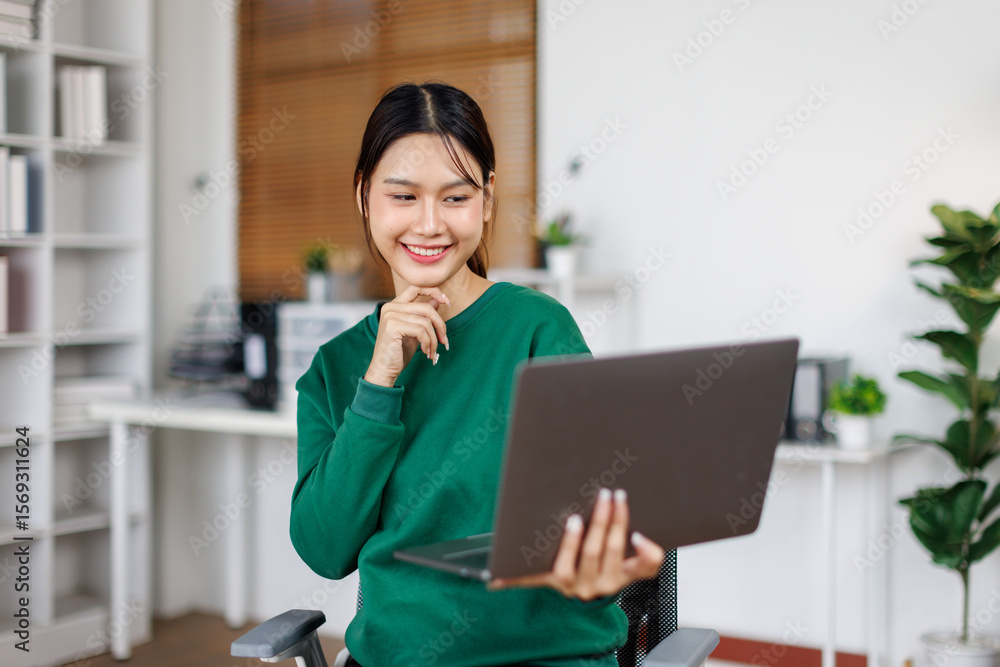 Portrait of Smiling a business asian woman working with laptop Sitting at Office Desk Portrait of Smiling a business asian woman working with laptop Sitting at Office Desk