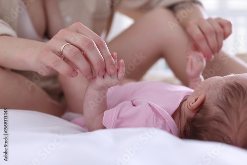 Mother with her newborn baby on bed at home, closeup