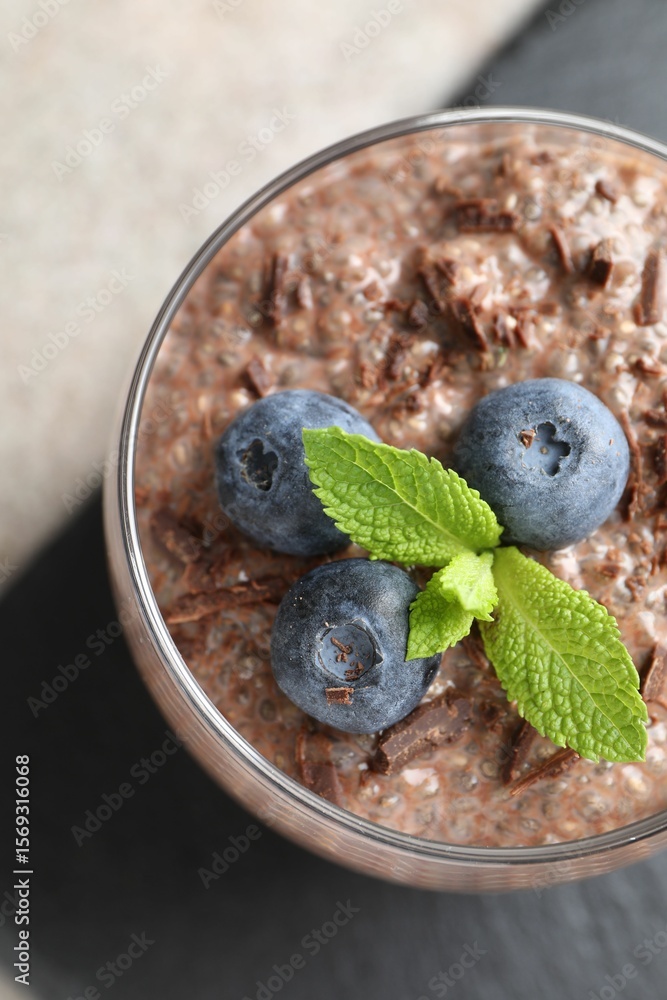Delicious chocolate pudding with chia seeds and blueberries in glass on light grey table, top view Delicious chocolate pudding with chia seeds and blueberries in glass on light grey table, top view