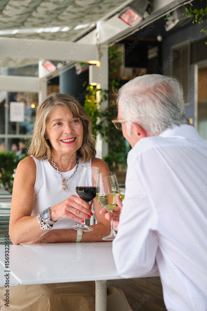 Happy mature couple enjoying a glass of wine together at a restaurant Happy mature couple enjoying a glass of wine together at a restaurant