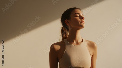 Young woman practicing mindfulness while standing in soft light  