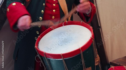 A military personnel playing the drums as part of a cultural event or entertainment