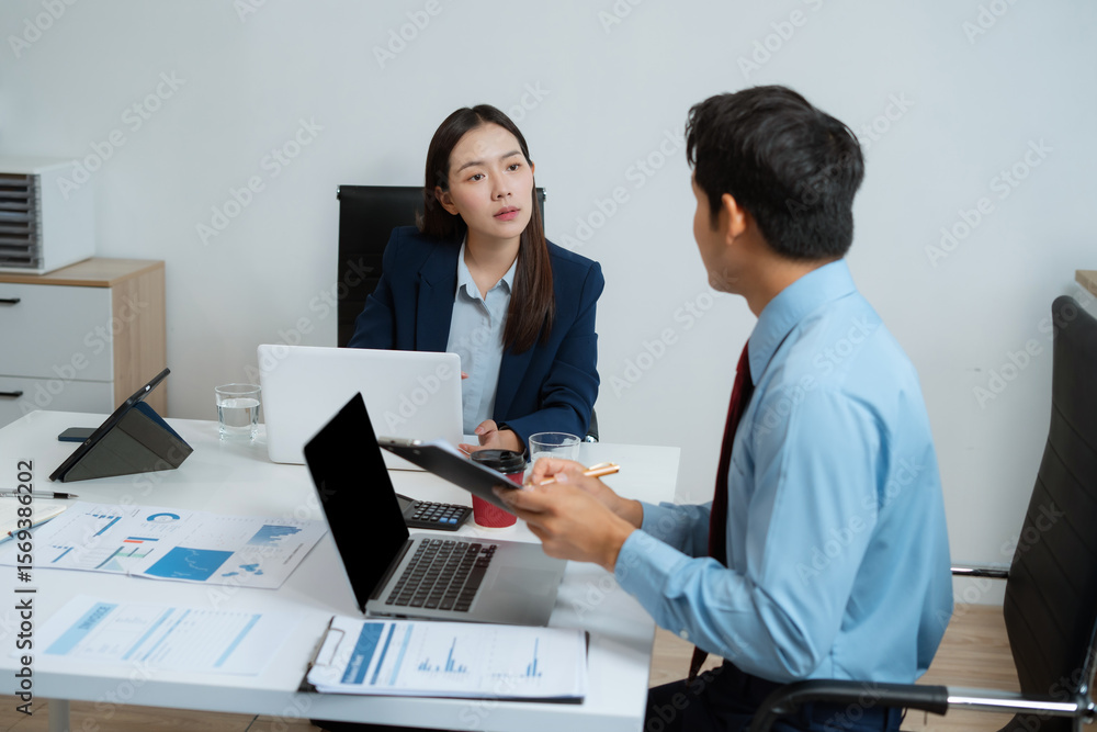 Business team analyzing documents, graphs, and data with a laptop, tablet, and smartphone. Collaboration, strategy, and success. Business team analyzing documents, graphs, and data with a laptop, tablet, and smartphone. Collaboration, strategy, and success.