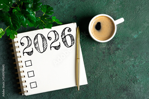 New year resolutions 2026 on desk. 2026 resolutions list with notebook, coffee cup on table. Goals, resolutions, plan, action, checklist concept. New Year 2026 template, copy space