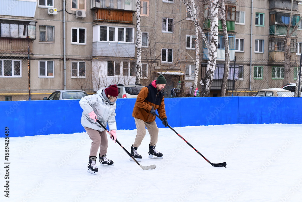 Obraz premium People skate and play ice hockey in the yard