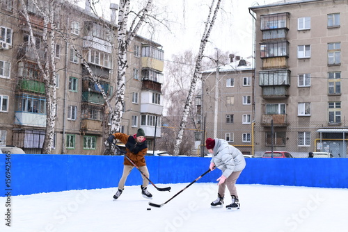 Canvas Print People skate and play ice hockey in the yard