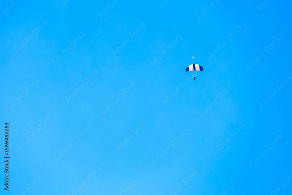 Fototapeta premium Skydiver parachuting against clear blue sky