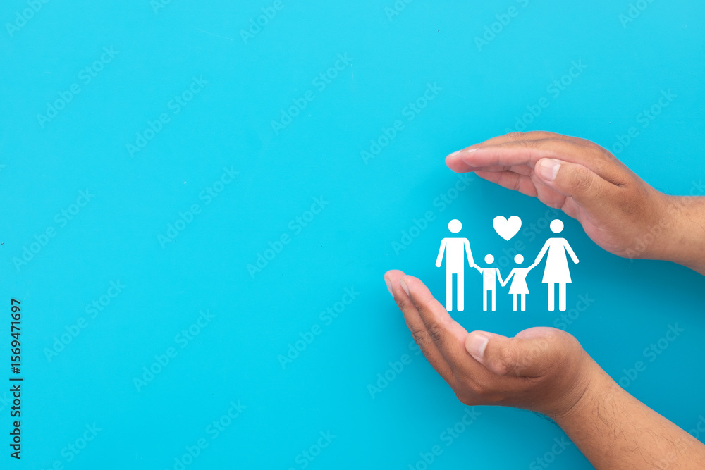 Fototapeta premium Family life and health insurance concept. Hands protecting a family icon with a love heart symbol. Represents financial planning,life assurance,medical coverage.,blue background with copyspace.