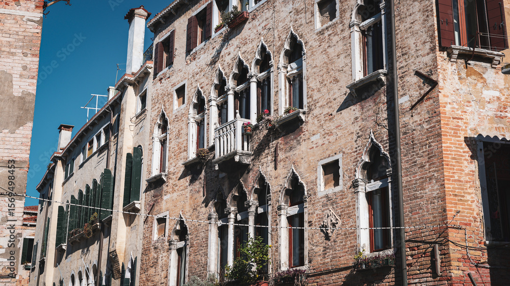 Fototapeta premium Venetian architecture with intricate window designs under clear skies