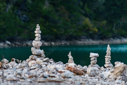 Artful stone cairns standing tall by tranquil waters. Representing stability, balance, and human connection with the natural world. A contemplative and inspiring image