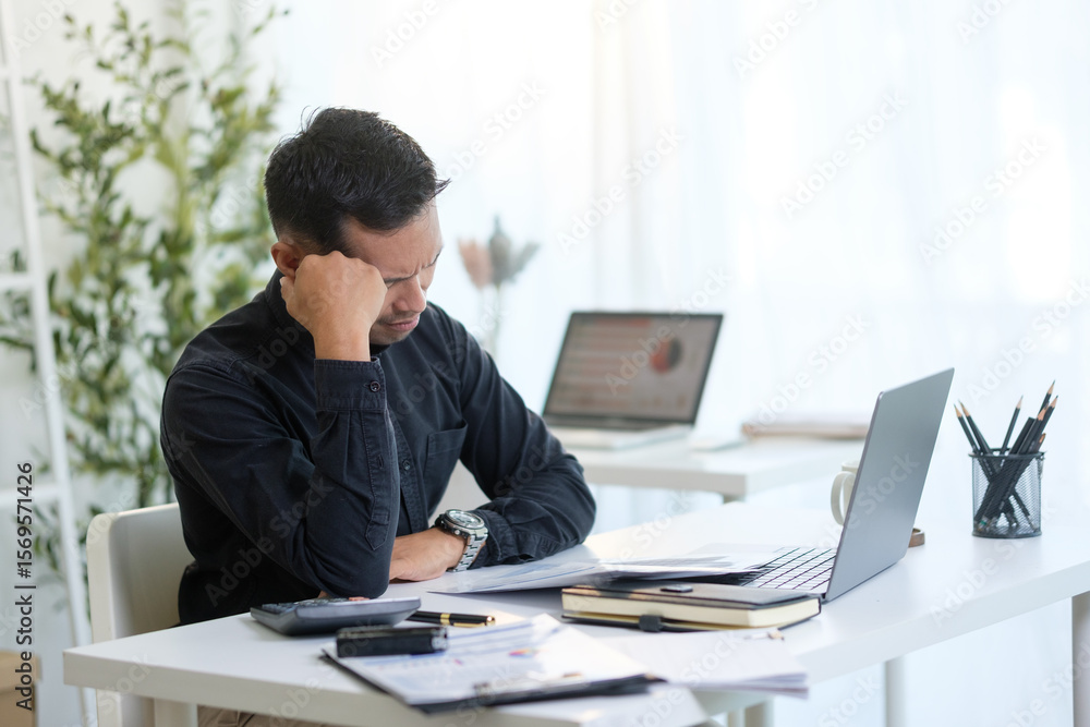 Overworked entrepreneur managing tasks and feeling pressure while working on a laptop in an office. Overworked entrepreneur managing tasks and feeling pressure while working on a laptop in an office.