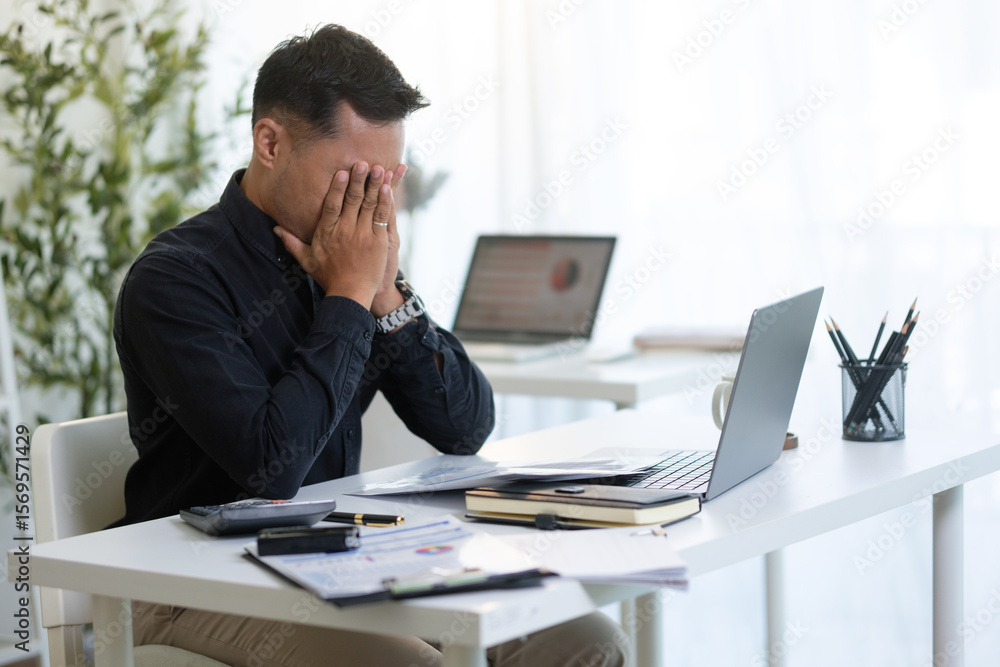 Overworked entrepreneur managing tasks and feeling pressure while working on a laptop in an office. Overworked entrepreneur managing tasks and feeling pressure while working on a laptop in an office.