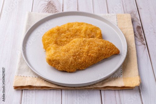 Tableau sur toile Milanese chicken breast over wooden table