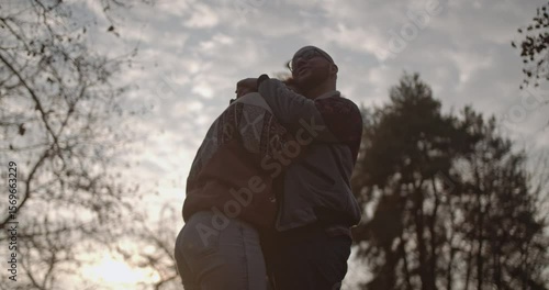 Wallpaper Mural A couple shares a tender embrace in a park at sunset. They hug, look into each other's eyes, and enjoy a romantic moment together. Torontodigital.ca