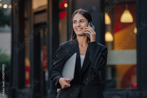 Elegant business woman talking by smartphone in the city