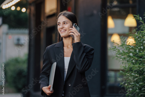 Elegant business woman talking by smartphone in the city